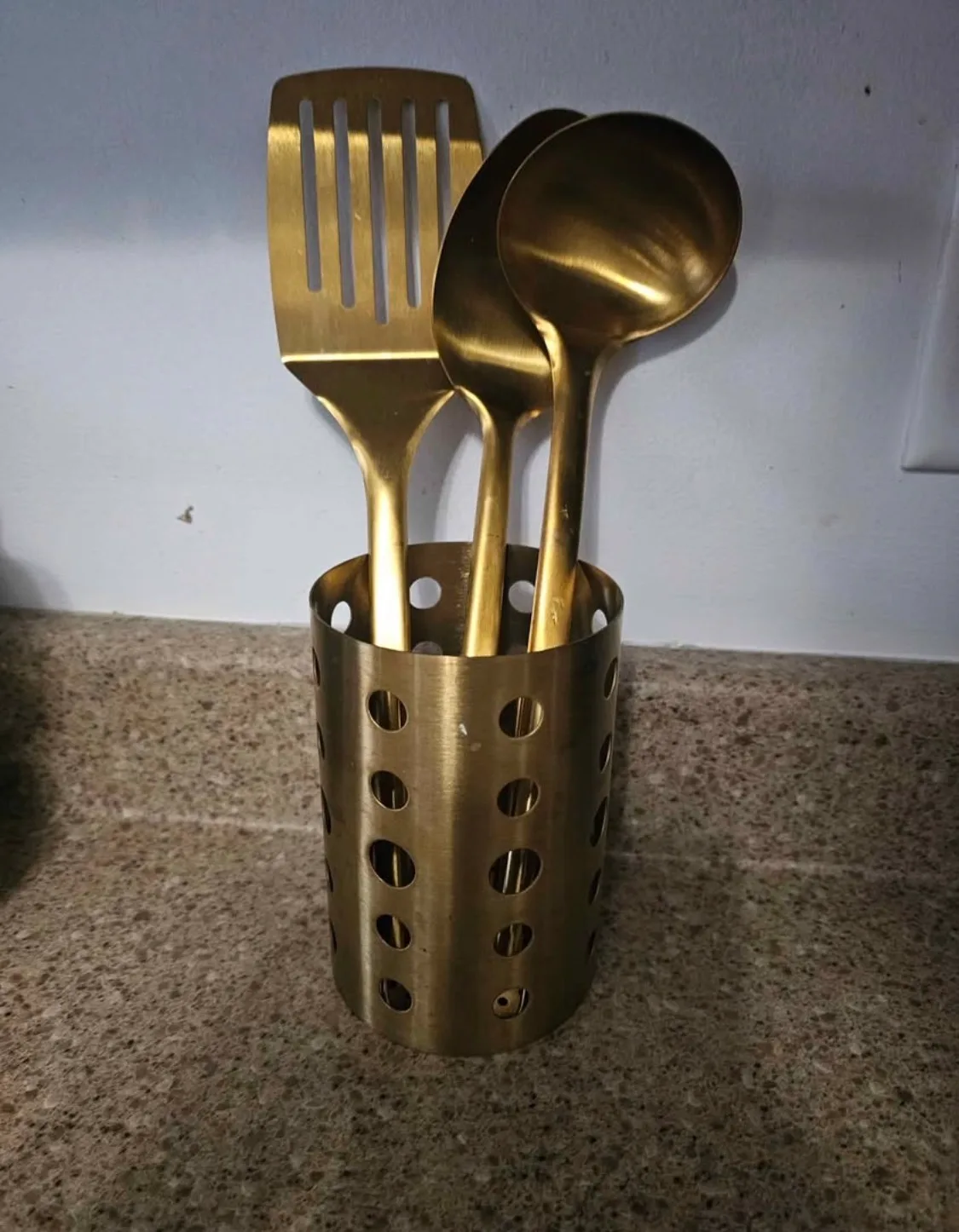 Ensemble d'ustensiles de cuisine en acier inoxydable doré.